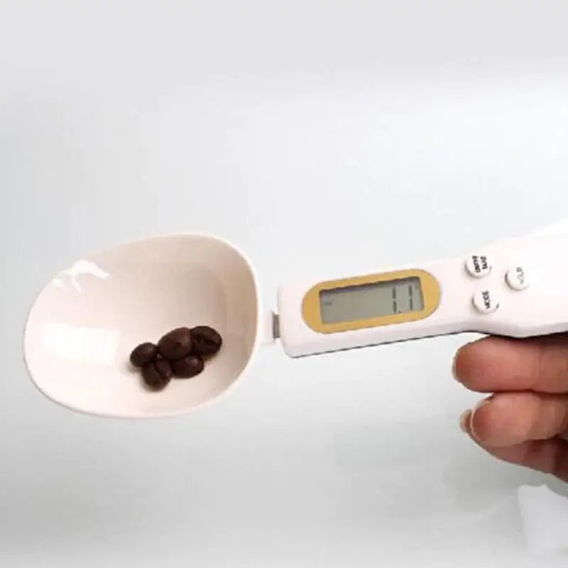 Digital spoon scale with coffee beans.